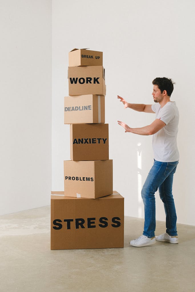 Side view of male in blue jeans touching stack of carton boxes with words break up work deadline anxiety problems
